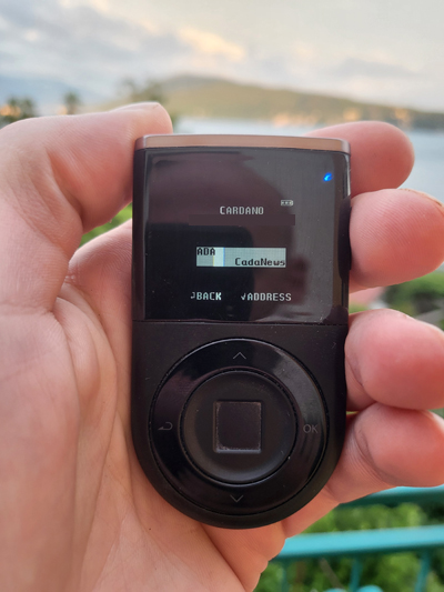 Cardano app on DCENT hardware wallet device shown in my hand.