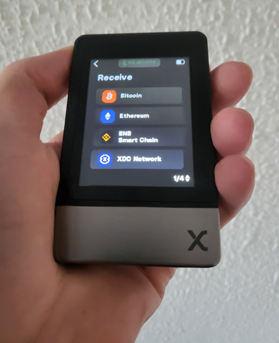 SecuX Neo X hardware wallet in hand showing Bitcoin, Ethereum, BNB, and XDC wallets.